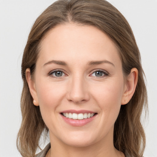 Joyful white young-adult female with long  brown hair and grey eyes