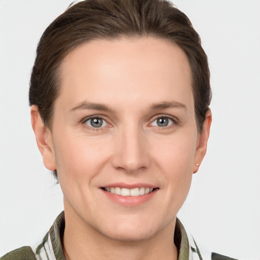 Joyful white young-adult female with short  brown hair and grey eyes