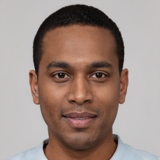 Joyful black young-adult male with short  black hair and brown eyes