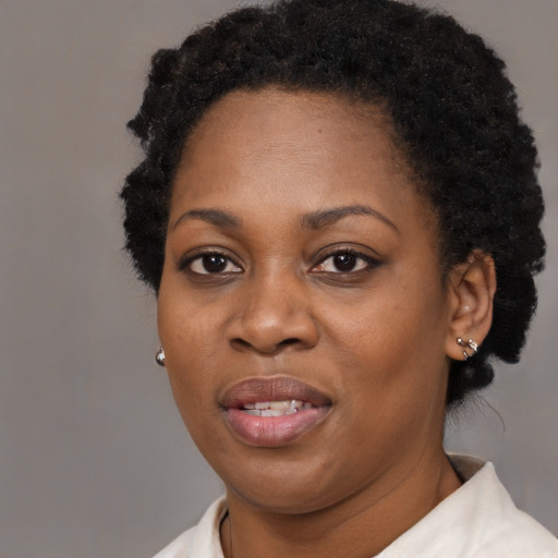 Joyful black young-adult female with short  black hair and brown eyes
