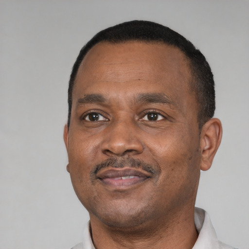 Joyful black adult male with short  black hair and brown eyes