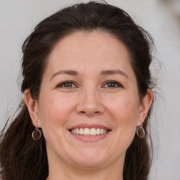 Joyful white adult female with medium  brown hair and grey eyes