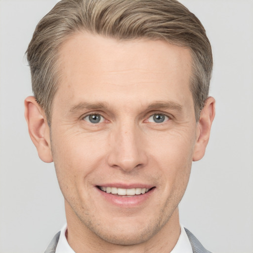 Joyful white adult male with short  brown hair and grey eyes