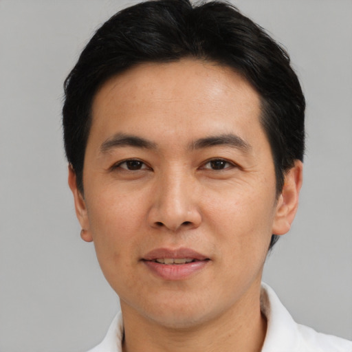 Joyful asian adult male with short  black hair and brown eyes