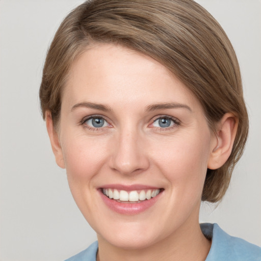 Joyful white young-adult female with medium  brown hair and grey eyes