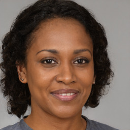 Joyful black adult female with medium  brown hair and brown eyes