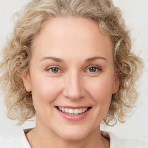 Joyful white young-adult female with medium  brown hair and blue eyes