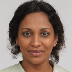 Joyful black adult female with medium  brown hair and brown eyes