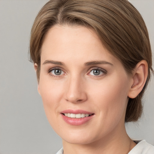 Joyful white young-adult female with medium  brown hair and grey eyes