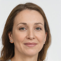 Joyful white adult female with long  brown hair and grey eyes