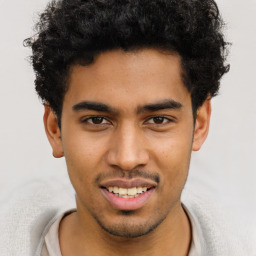 Joyful latino young-adult male with short  brown hair and brown eyes