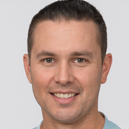 Joyful white adult male with short  brown hair and brown eyes