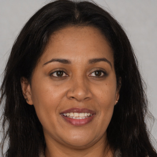 Joyful latino adult female with long  brown hair and brown eyes