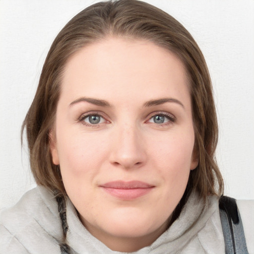 Joyful white young-adult female with medium  brown hair and blue eyes