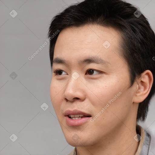 Joyful asian young-adult male with short  brown hair and brown eyes