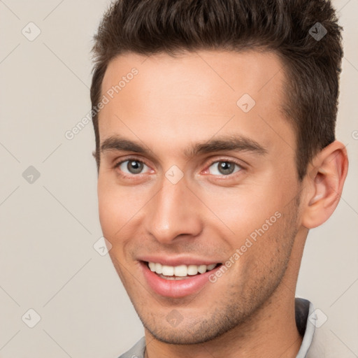 Joyful white young-adult male with short  brown hair and brown eyes