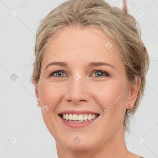 Joyful white young-adult female with medium  brown hair and blue eyes