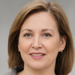 Joyful white adult female with medium  brown hair and grey eyes