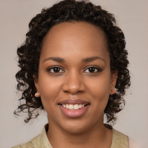 Joyful black young-adult female with medium  brown hair and brown eyes