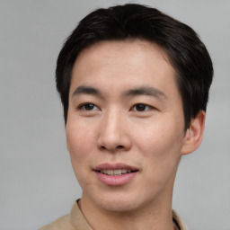 Joyful asian young-adult male with short  brown hair and brown eyes