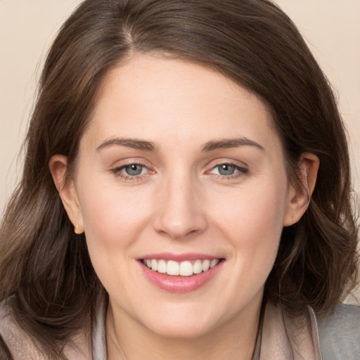 Joyful white young-adult female with long  brown hair and grey eyes