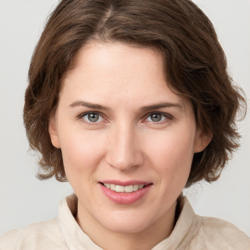 Joyful white young-adult female with medium  brown hair and grey eyes