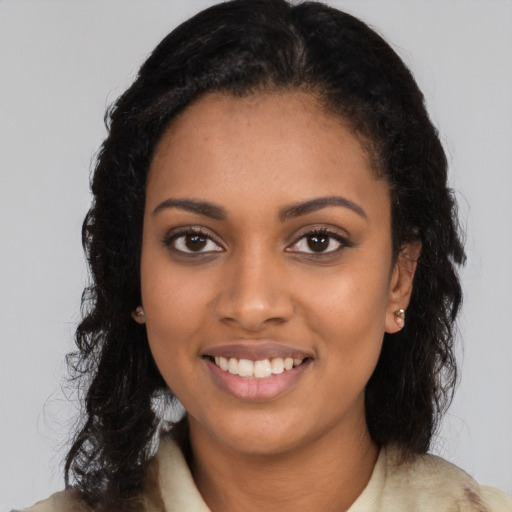 Joyful black young-adult female with long  brown hair and brown eyes