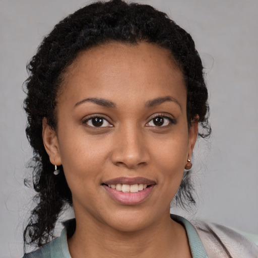 Joyful black young-adult female with short  brown hair and brown eyes