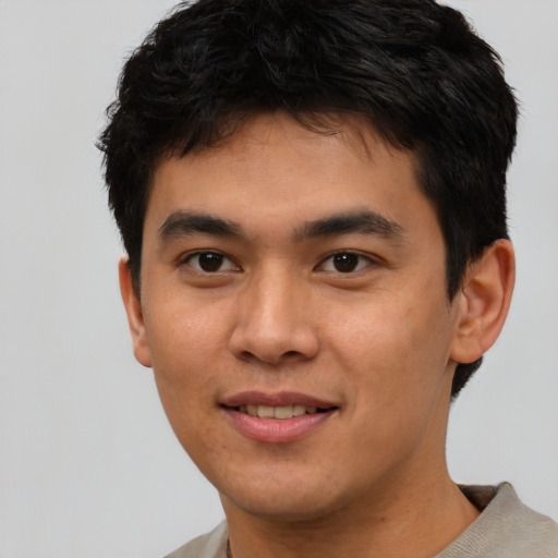 Joyful asian young-adult male with short  brown hair and brown eyes