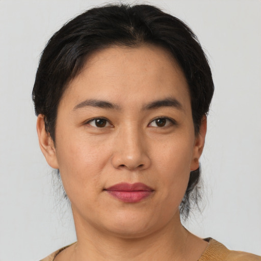 Joyful asian young-adult female with short  black hair and brown eyes