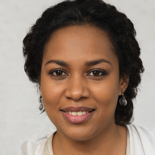 Joyful black young-adult female with long  brown hair and brown eyes