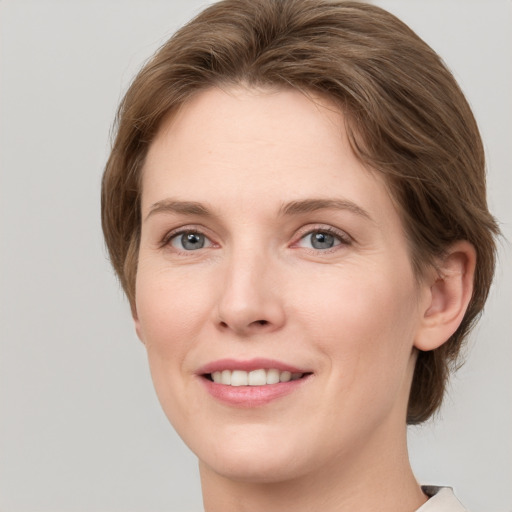 Joyful white young-adult female with medium  brown hair and grey eyes