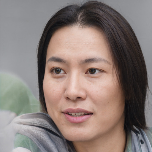 Joyful asian young-adult female with medium  brown hair and brown eyes