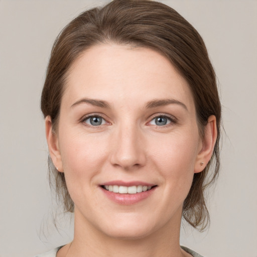 Joyful white young-adult female with medium  brown hair and grey eyes