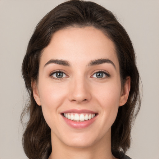 Joyful white young-adult female with medium  brown hair and brown eyes