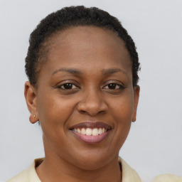 Joyful black young-adult female with short  brown hair and brown eyes
