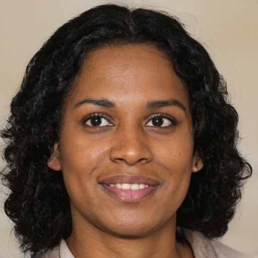 Joyful black young-adult female with medium  brown hair and brown eyes