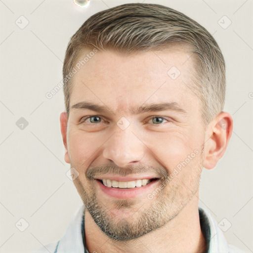 Joyful white young-adult male with short  brown hair and grey eyes