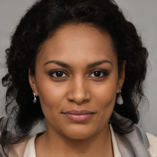 Joyful black young-adult female with long  brown hair and brown eyes