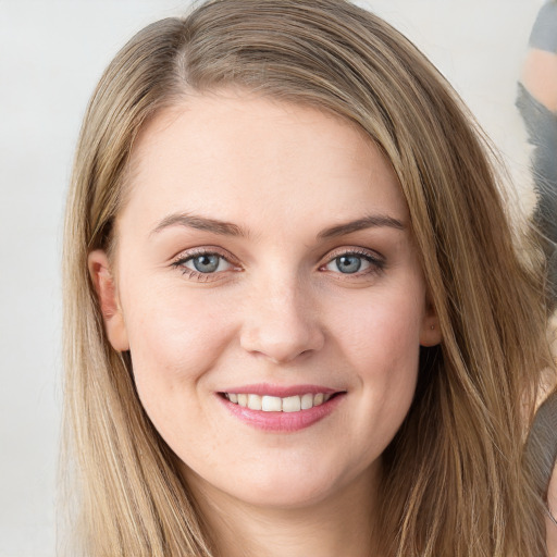 Joyful white young-adult female with long  brown hair and blue eyes