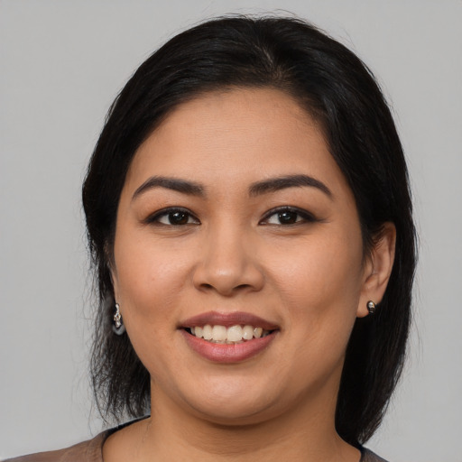 Joyful latino young-adult female with long  black hair and brown eyes