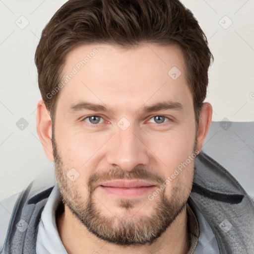 Joyful white young-adult male with short  brown hair and grey eyes