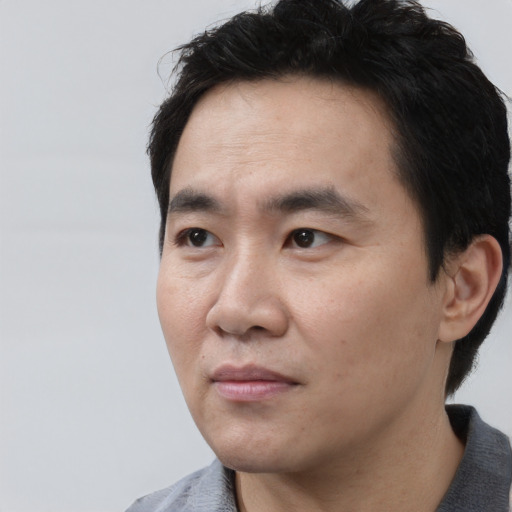 Neutral asian adult male with short  black hair and brown eyes
