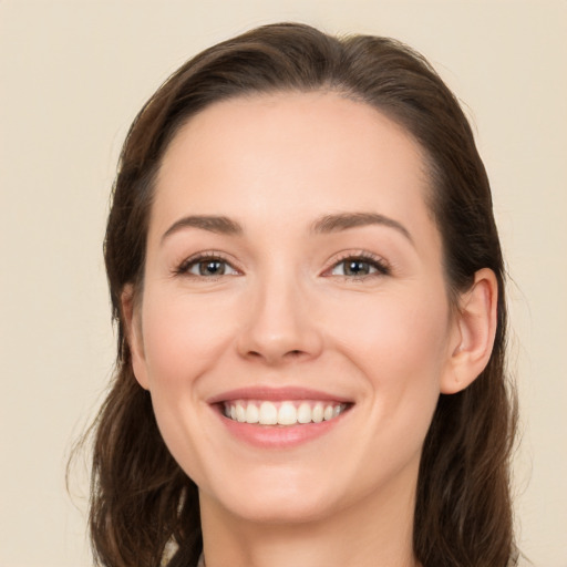 Joyful white young-adult female with long  brown hair and brown eyes