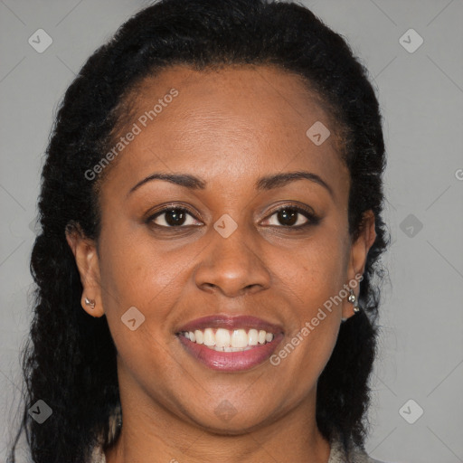 Joyful black adult female with long  brown hair and brown eyes