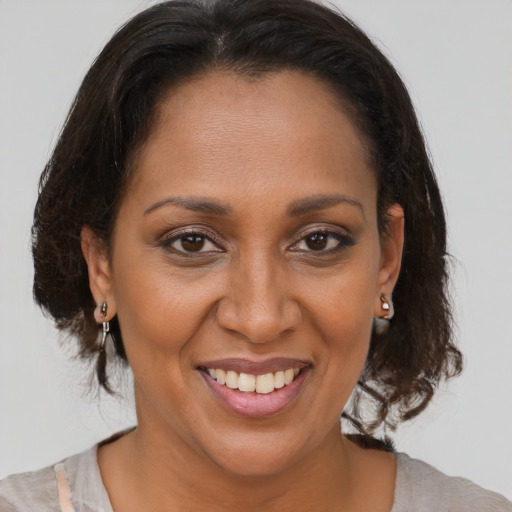 Joyful black adult female with medium  brown hair and brown eyes