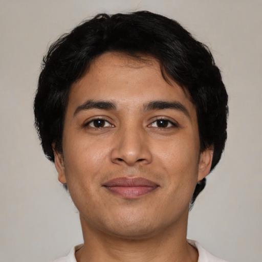 Joyful latino young-adult male with short  brown hair and brown eyes