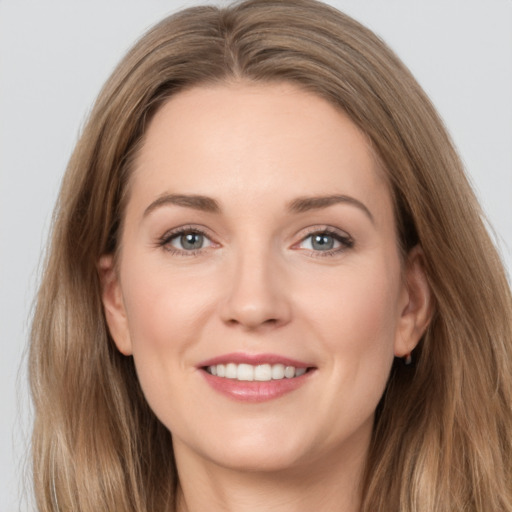 Joyful white young-adult female with long  brown hair and grey eyes