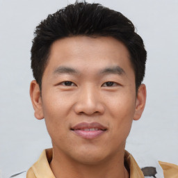 Joyful asian young-adult male with short  black hair and brown eyes