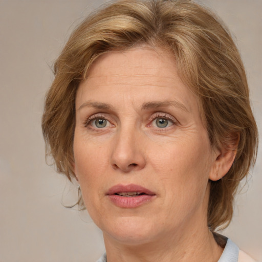 Joyful white adult female with medium  brown hair and blue eyes